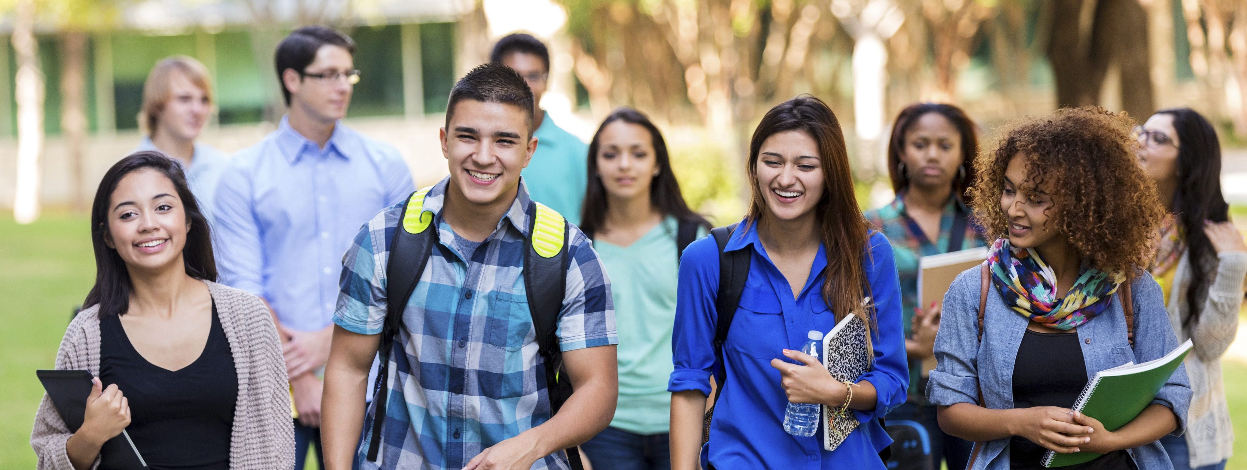 Старшеклассники в школе у доски. Веселые студенты. Дружелюбный человек. Поднятые руки в школе сток. Девочка у доски.